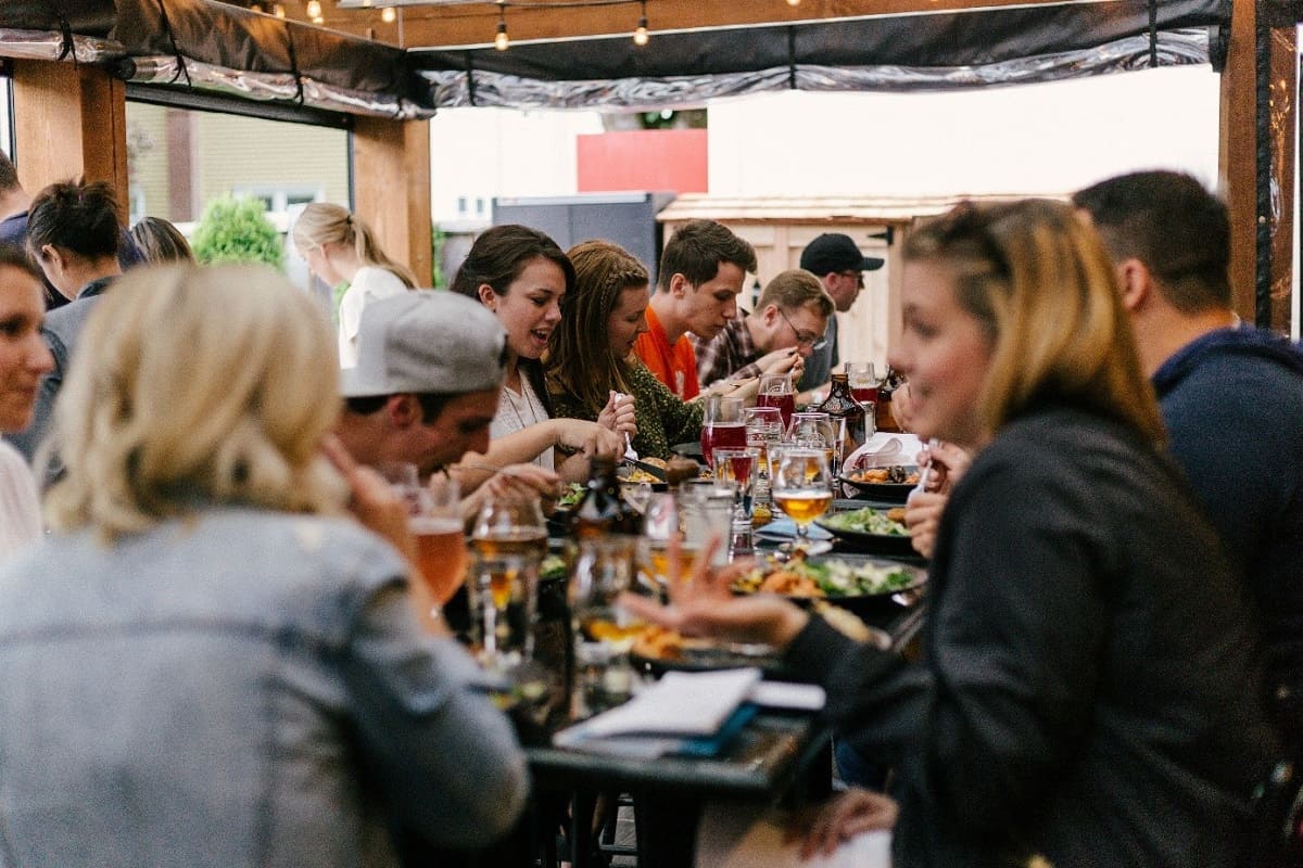 Mehrere Menschen, die an einem Tisch sitzen und essen