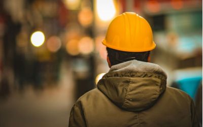 Arbeiter mit Helm von hinten fotografiert